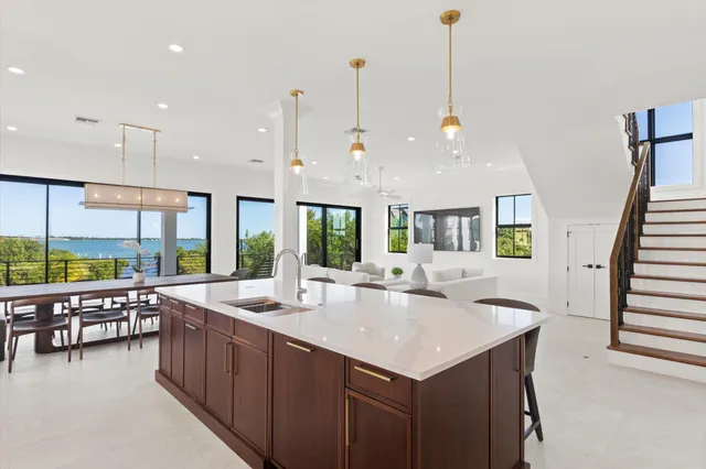 a open kitchen with a sink a counter top space and living room view