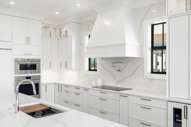 a kitchen with white cabinets and stainless steel appliances