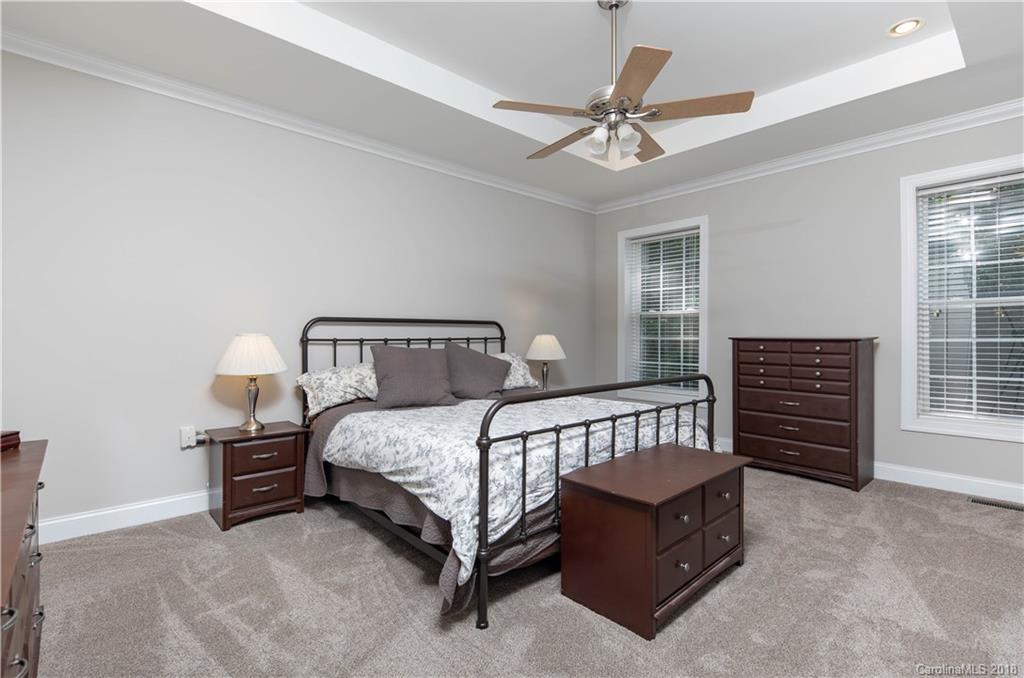 1334 Crown Ridge Drive Fort Mill, SC 29708 - Photo 11 of 25 a bedroom with a bed a dresser and a chandelier