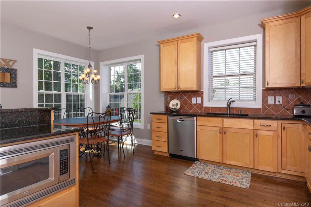 1334 Crown Ridge Drive Fort Mill, SC 29708 - Photo 8 of 25 a kitchen with stainless steel appliances granite countertop wooden floors stove top oven and sink