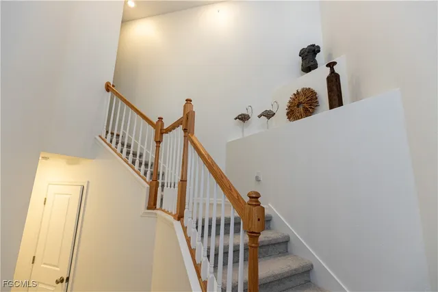 a view of staircase with railing and white walls