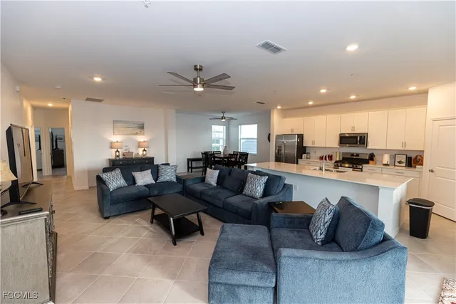 a living room with furniture kitchen and a wooden floor