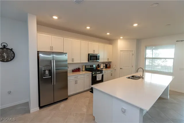 a kitchen with stainless steel appliances a refrigerator sink and microwave