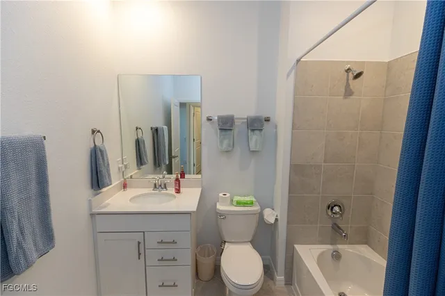 a bathroom with a bathtub shower sink mirror vanity and toilet