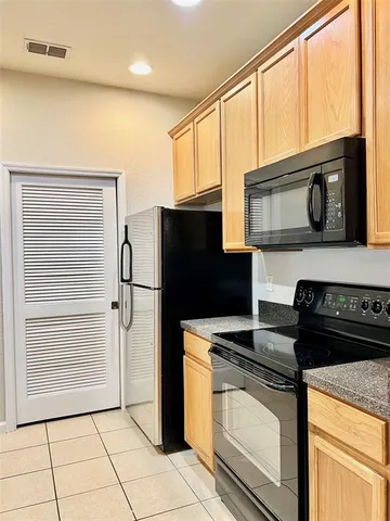 a kitchen with granite countertop cabinets stainless steel appliances and a window