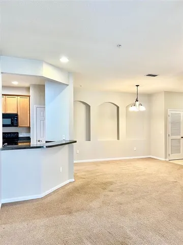 a view of kitchen with stainless steel appliances granite countertop a stove a sink and a refrigerator
