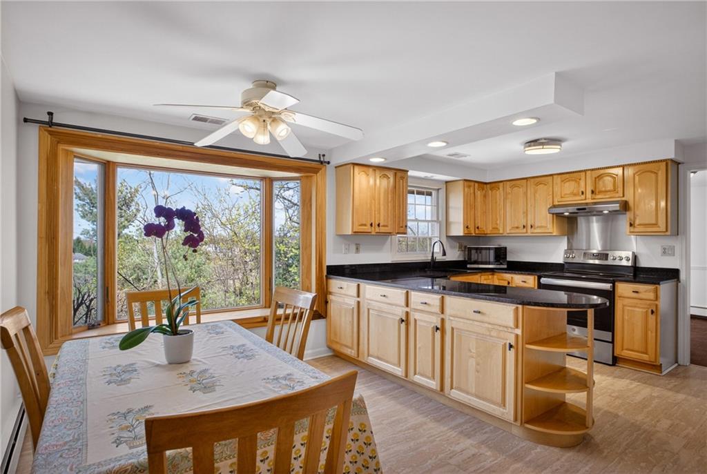 1768 Taper Drive Pittsburgh, PA 15241 - Photo 19 of 48 a kitchen with stainless steel appliances granite countertop a stove a refrigerator a sink dishwasher a dining table and chairs with wooden floor