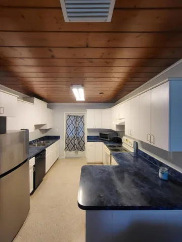 a kitchen with granite countertop white cabinets and stainless steel appliances