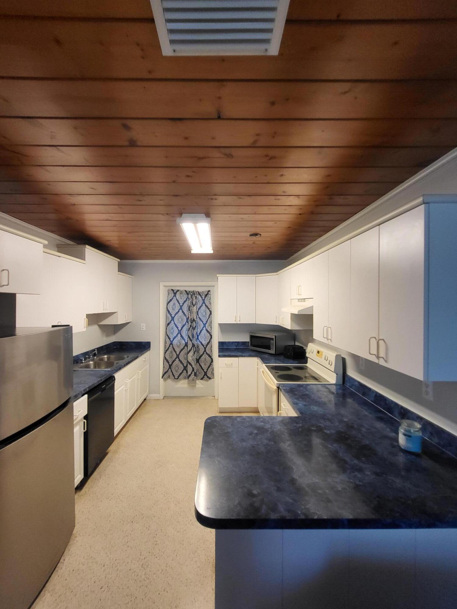 1169 Seaway Drive, Unit B Fort Pierce, FL 34949 - Photo 3 of 8 a large room with stainless steel appliances wooden cabinets