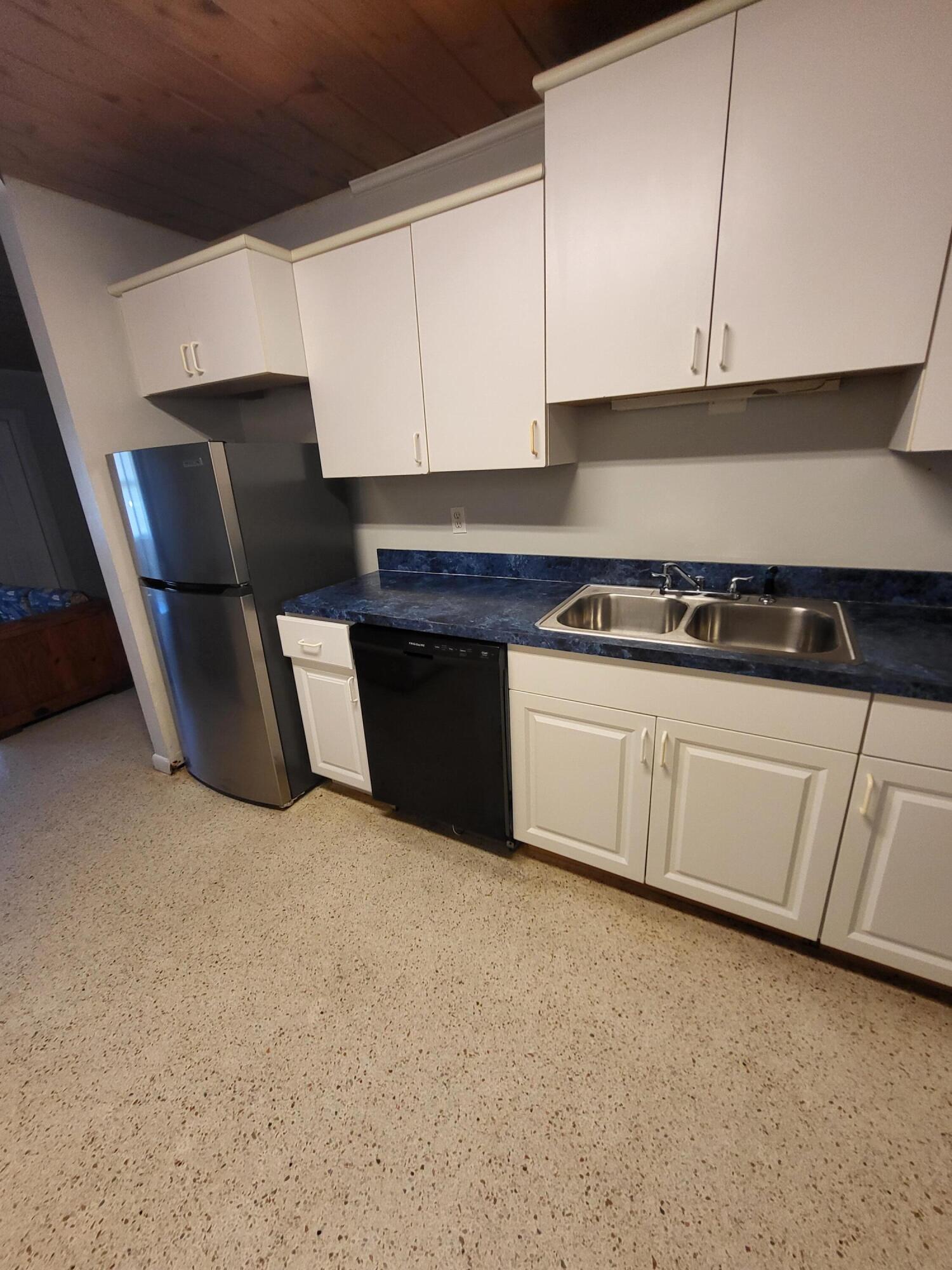 1169 Seaway Drive, Unit B Fort Pierce, FL 34949 - Photo 4 of 8 a kitchen with granite countertop white cabinets and stainless steel appliances