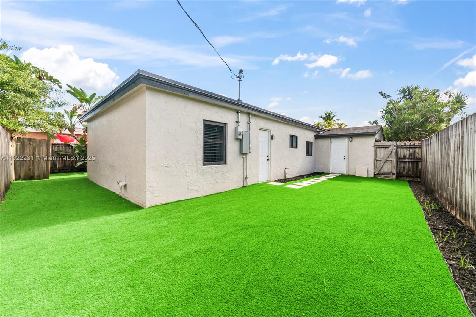 1671 Northeast 174th Street, Unit 1671 North Miami Beach, FL 33162 - Photo 21 of 21 a view of a white house with backyard and garden