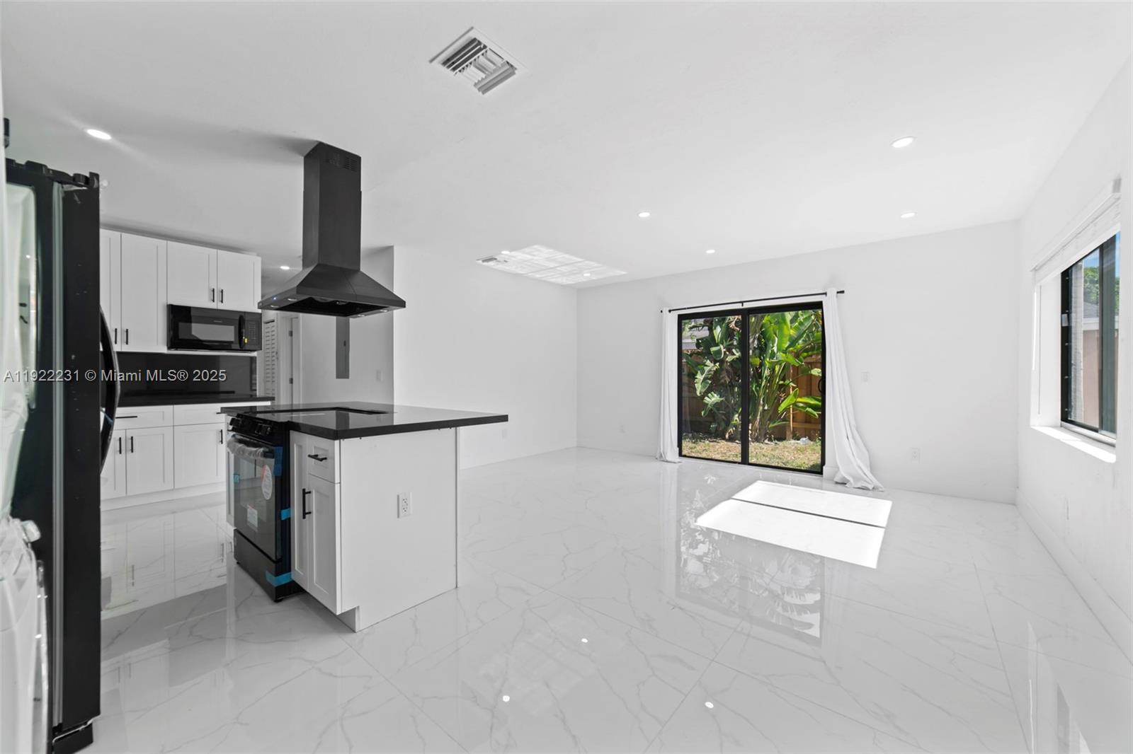 1671 Northeast 174th Street, Unit 1671 North Miami Beach, FL 33162 - Photo 4 of 21 a kitchen with stainless steel appliances kitchen island sink refrigerator and microwave