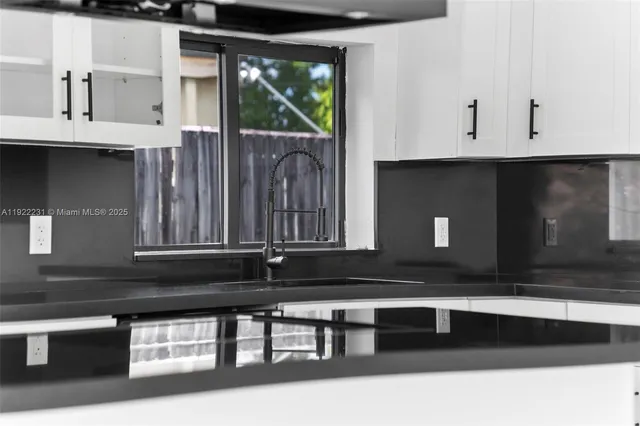 a kitchen with stainless steel appliances a refrigerator sink and white cabinets