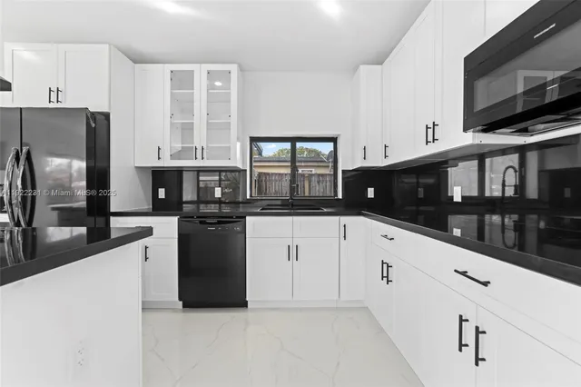 a kitchen with stainless steel appliances granite countertop a sink a stove and a refrigerator