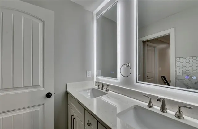 a kitchen with white cabinets and sink