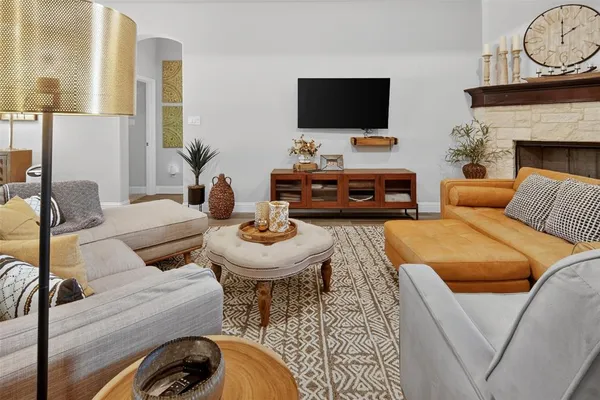 a living room with furniture a fireplace and a flat screen tv