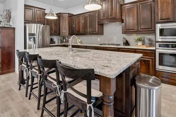 a kitchen with granite countertop a table chairs stove and cabinets