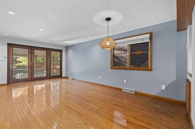 a view of an empty room with window and wooden floor