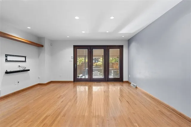 a view of a hallway with wooden floor and a bathroom