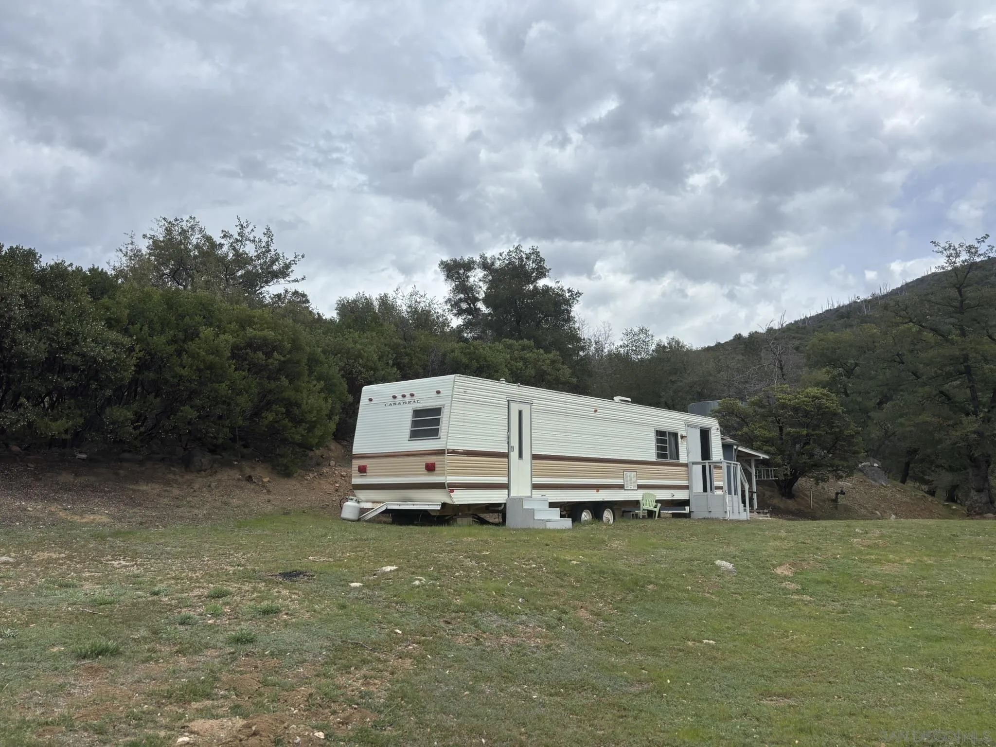 7317 Starlight Way Julian, CA 92036 - Photo 5 of 19 a view of a white house with a big yard and large trees
