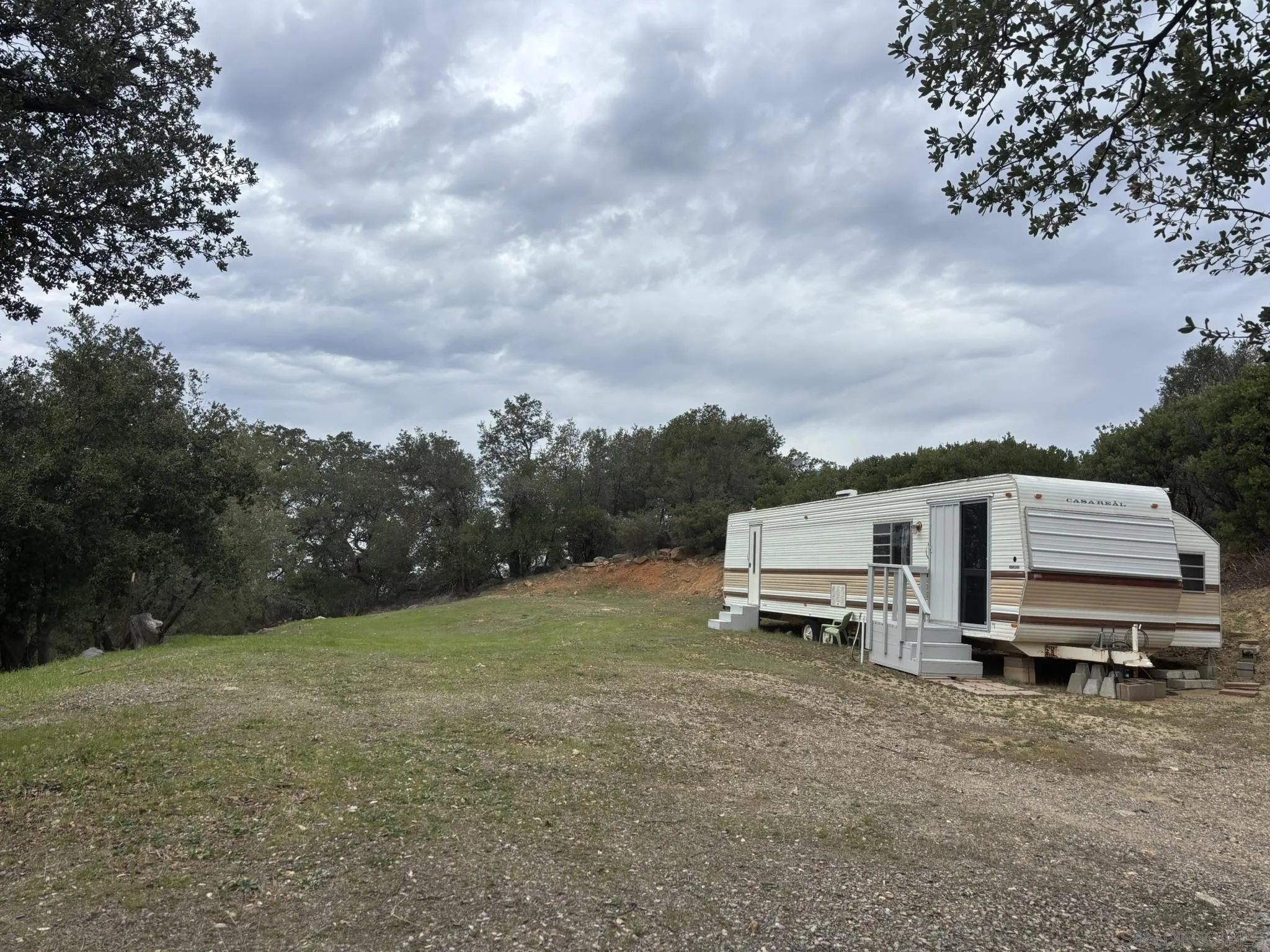 7317 Starlight Way Julian, CA 92036 - Photo 8 of 19 a view of a white house with a big yard and large trees
