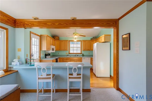 a dining room with a table chairs and a kitchen view