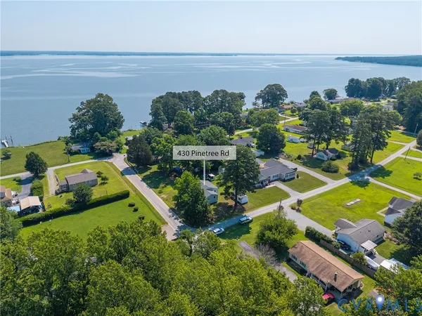 an aerial view of a house with a garden and lake view