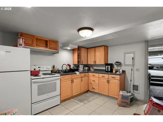 a kitchen with stainless steel appliances a sink a stove a refrigerator cabinets and a window