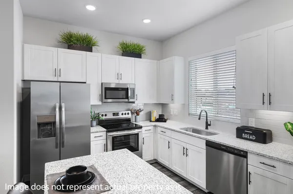 a kitchen with a sink stainless steel appliances and white cabinets