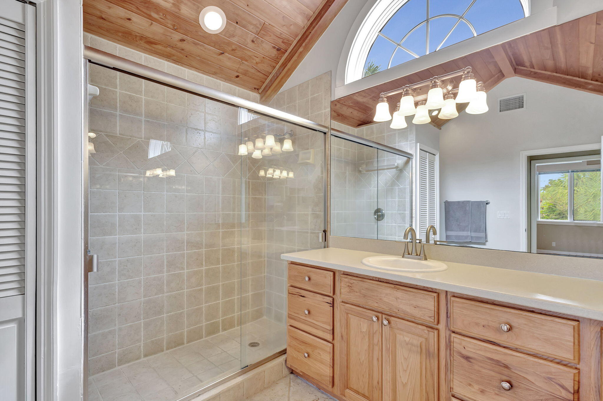 18199 April Lane Jupiter, FL 33458 - Photo 32 of 70 a bathroom with a sink mirror and a shower