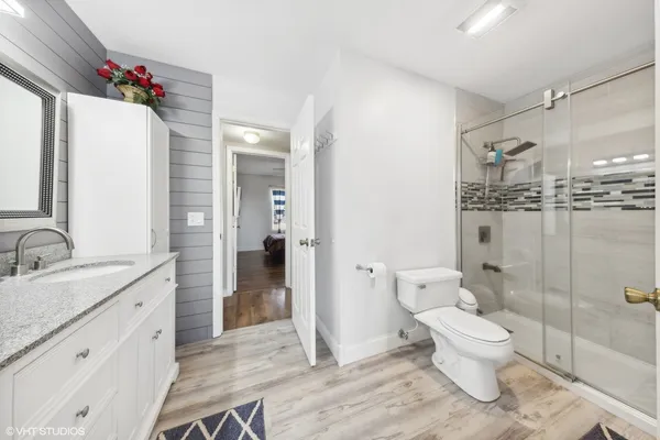 a bathroom with a sink a toilet and shower