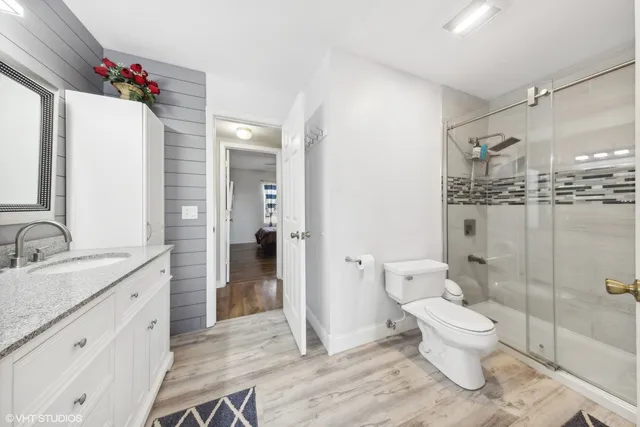 a bathroom with a sink a toilet and shower