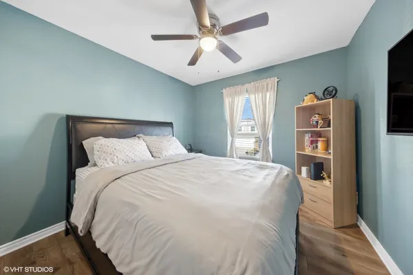 a bedroom with a bed and a flat tv screen on dresser