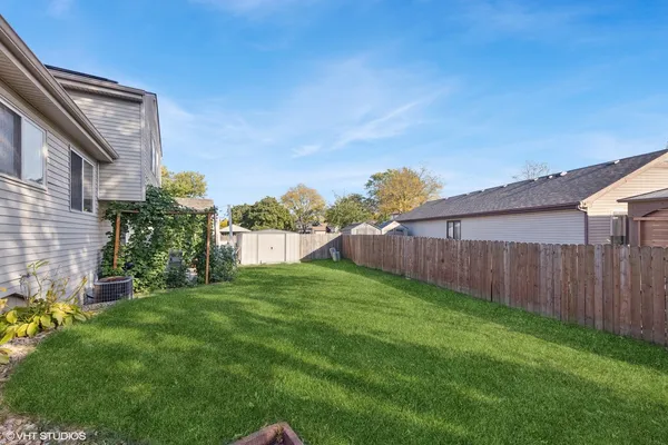 a view of a backyard with potted plants and wooden fence
