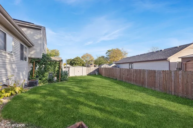 a view of a backyard with potted plants and wooden fence