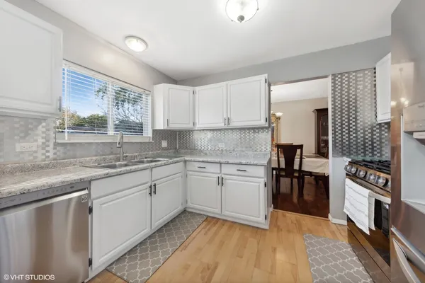a kitchen with granite countertop a sink stove and cabinets