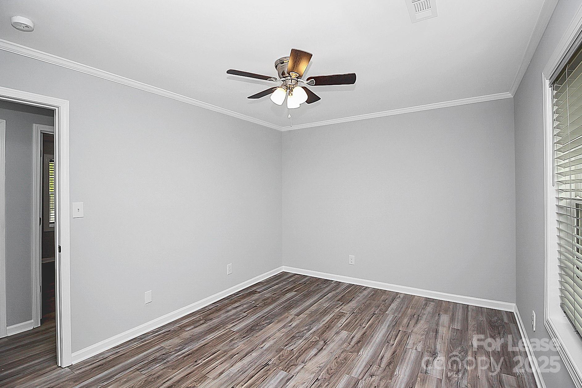1027 Little Avenue, Unit D Gastonia, NC 28052 - Photo 13 of 20 a view of empty room with wooden floor and fan