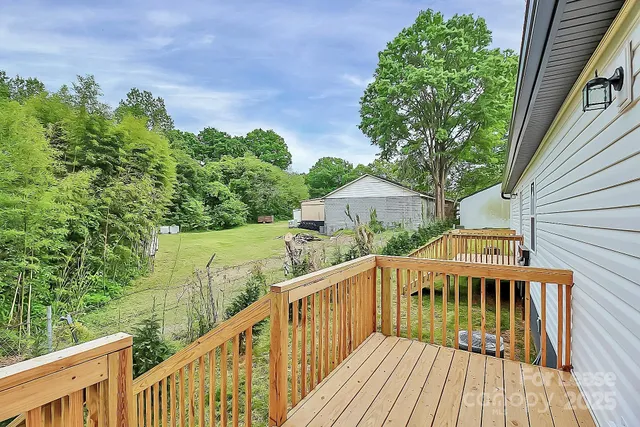 a view of a house with wooden deck and trees