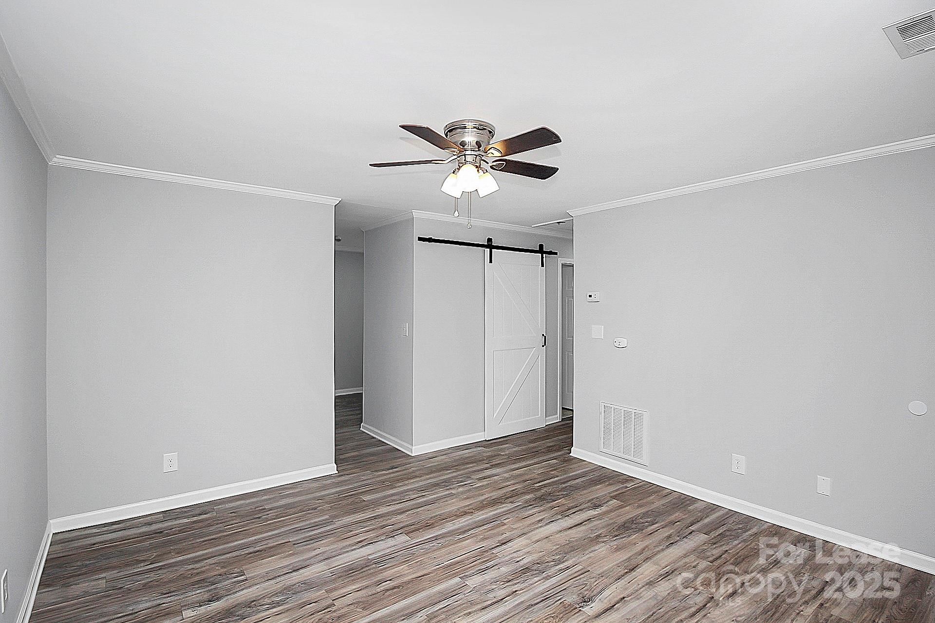 1027 Little Avenue, Unit D Gastonia, NC 28052 - Photo 3 of 20 a view of a room with wooden floor and a ceiling fan