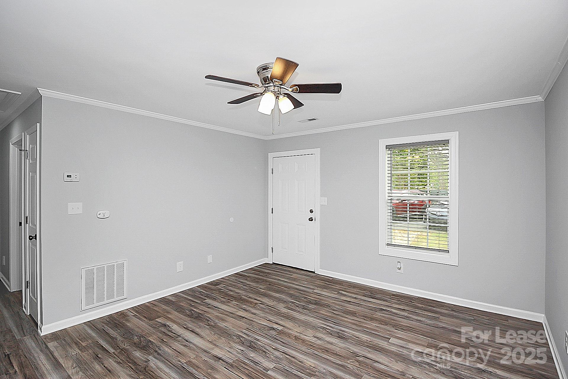 1027 Little Avenue, Unit D Gastonia, NC 28052 - Photo 4 of 20 a view of a room with wooden floor and a ceiling fan