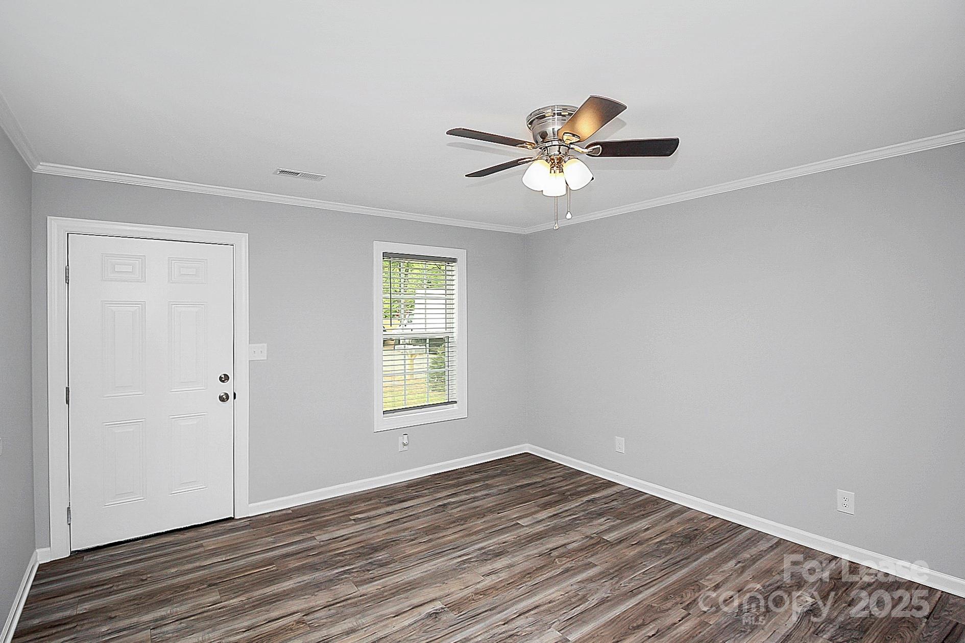 1027 Little Avenue, Unit D Gastonia, NC 28052 - Photo 5 of 20 a view of empty room with wooden floor and fan