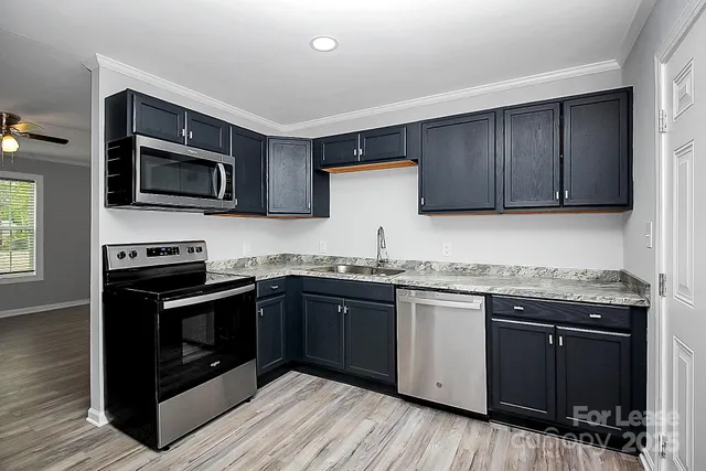 a kitchen with granite countertop wooden cabinets and stainless steel appliances