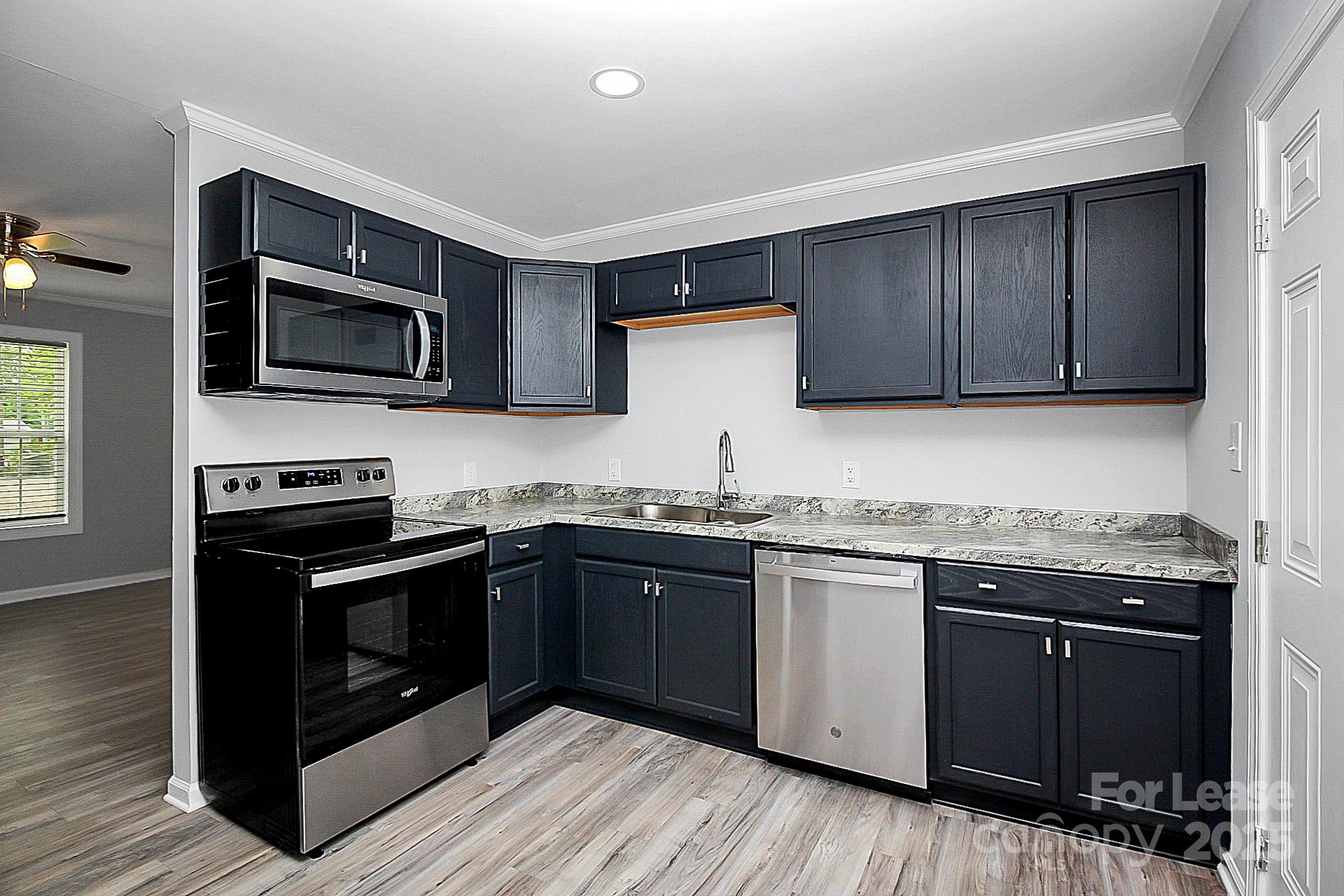 1027 Little Avenue, Unit D Gastonia, NC 28052 - Photo 6 of 20 a kitchen with granite countertop wooden cabinets and stainless steel appliances