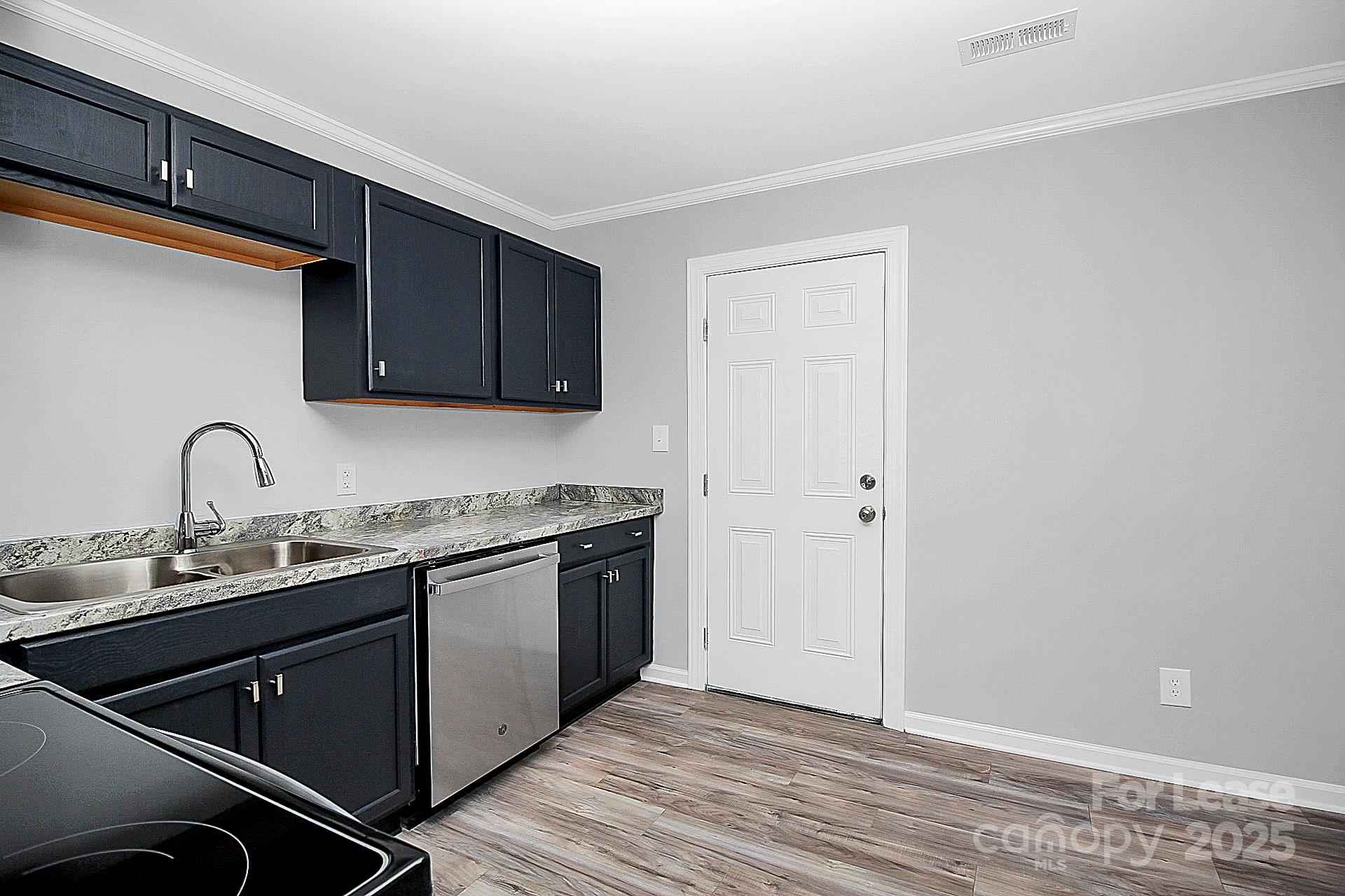 1027 Little Avenue, Unit D Gastonia, NC 28052 - Photo 7 of 20 a kitchen with stainless steel appliances granite countertop a sink and wooden cabinets