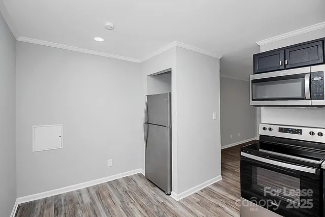a kitchen with a refrigerator and a stove top oven