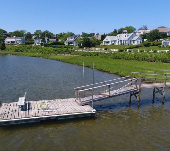 a view of a lake with a yard and potted plants