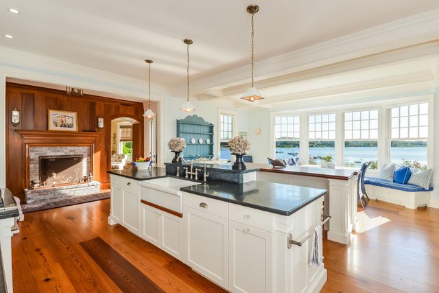 a kitchen with stainless steel appliances granite countertop a stove a sink and a wooden floor