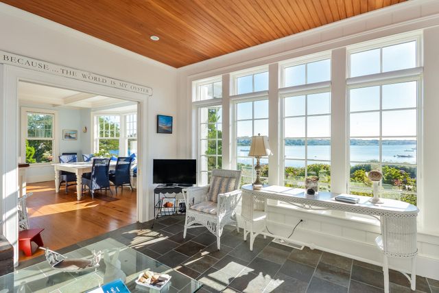 a living room with furniture a flat screen tv and a floor to ceiling window