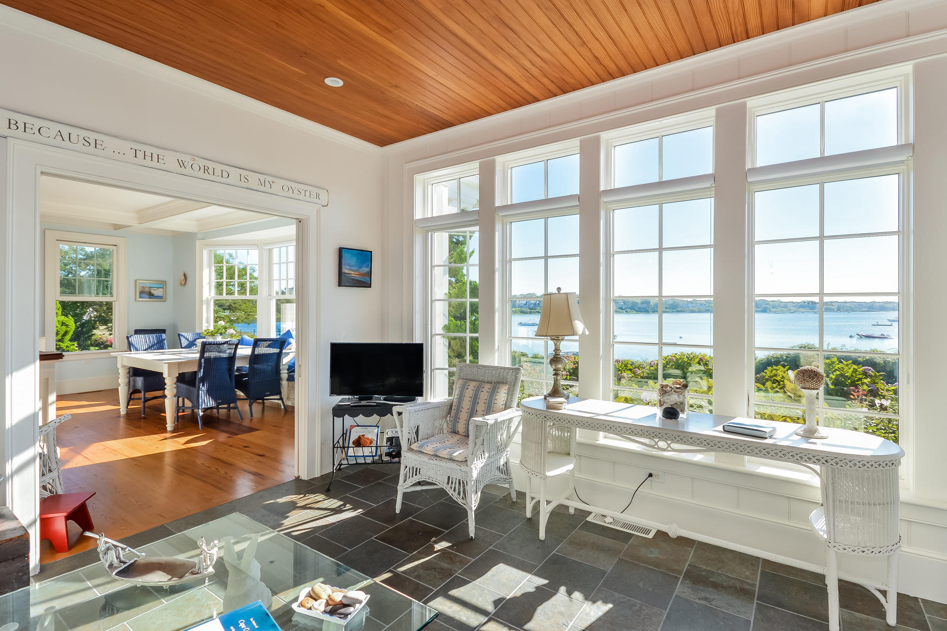 58 Pond Street Chatham, MA 02633 - Photo 28 of 38 a living room with furniture a flat screen tv and a floor to ceiling window