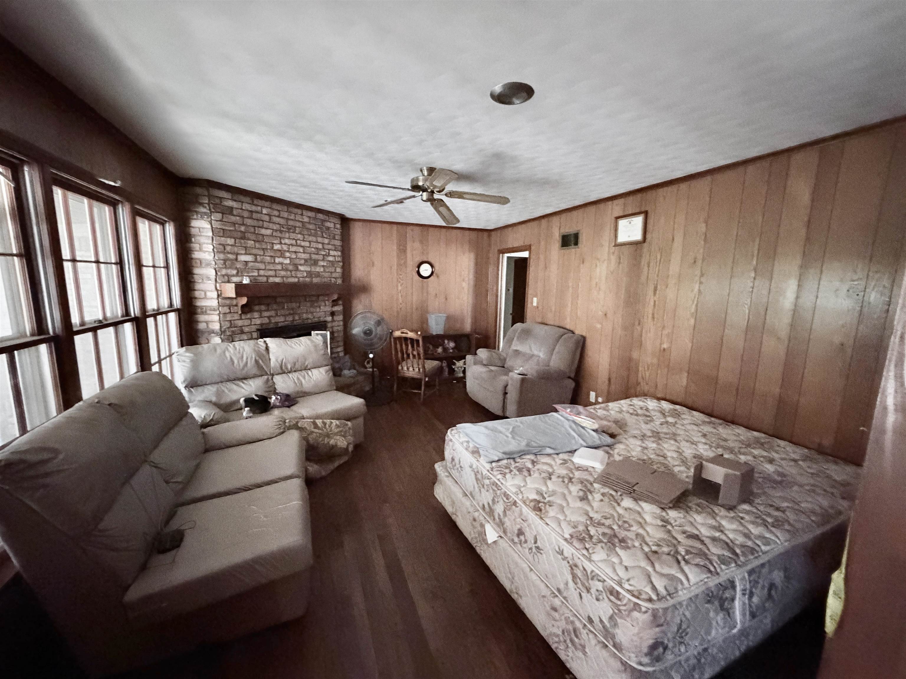 5536 Cottonwood Road Memphis, TN 38115 - Photo 12 of 28 Living area featuring wood-finish flooring, a brick fireplace with a wood mantel, and expansive windows